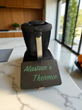 Black thermomix tm7 with 'Alastair's Thermie' branding on a kitchen counter.