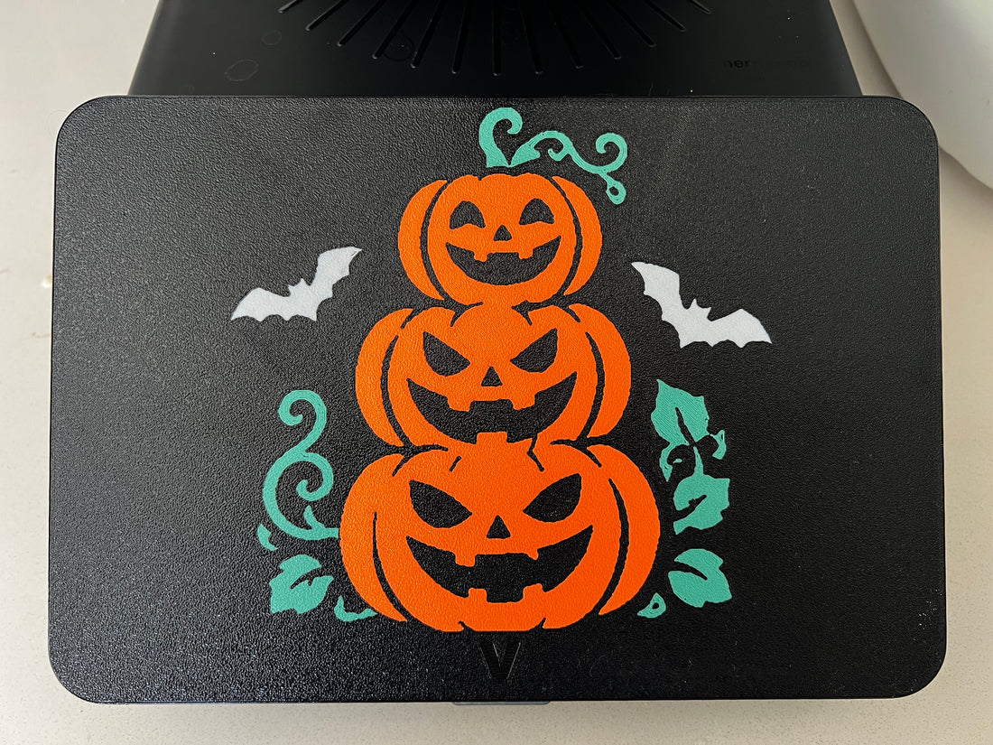Pumpkin stack Halloween screen cover on a Thermomix TM7 — three orange jack-o'-lanterns with white bats and teal vines on black